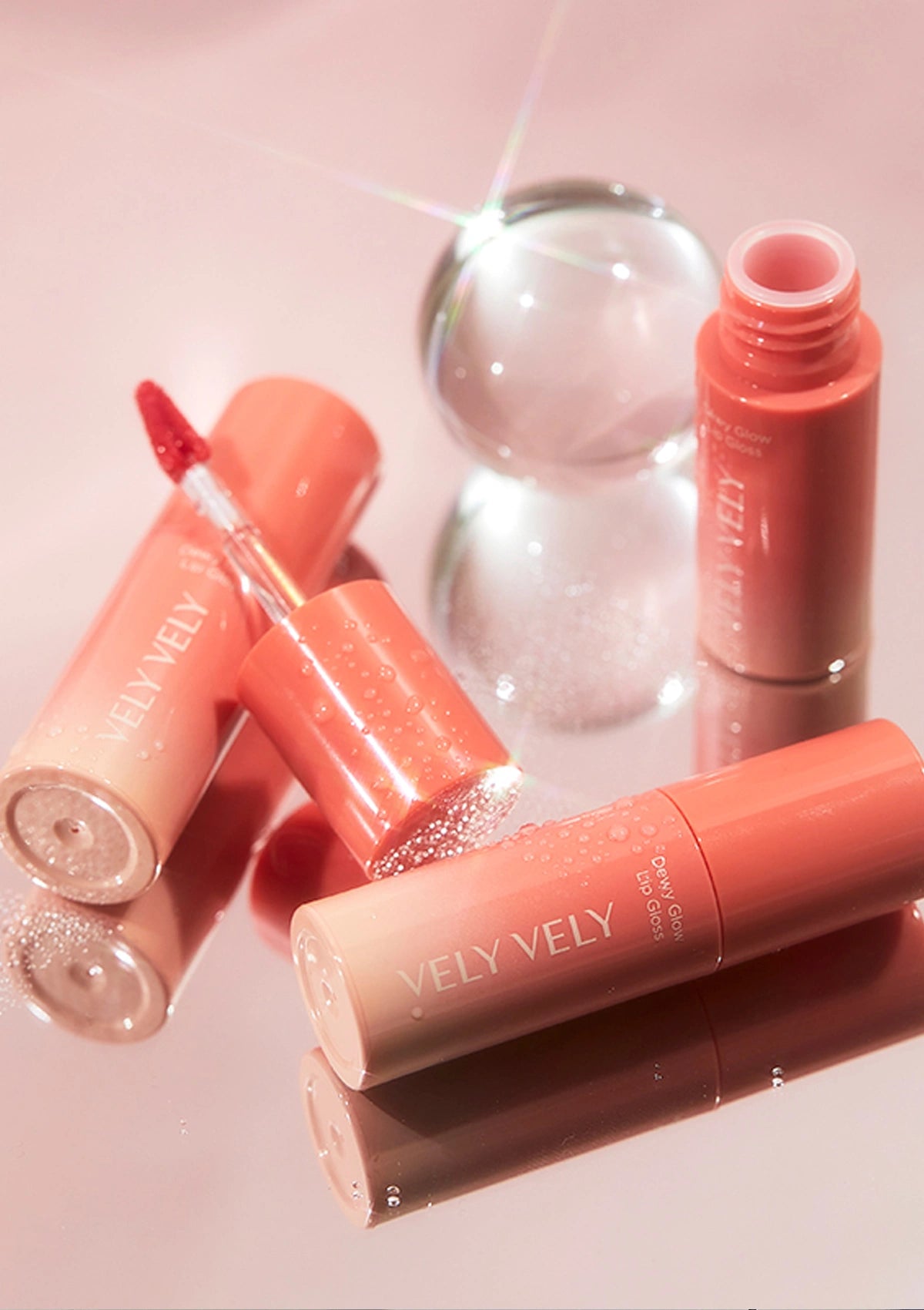 Vely Vely lip glosses on a pink background